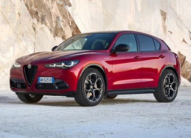Červené Alfa Romeo Stelvio zaparkované pred svetlou skalnou stenou mramorového lomu