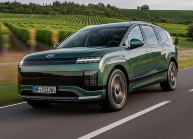 Tmavozelené sedemmiestne elektrické SUV Hyundai Ioniq 9 v jazde popri viniciach