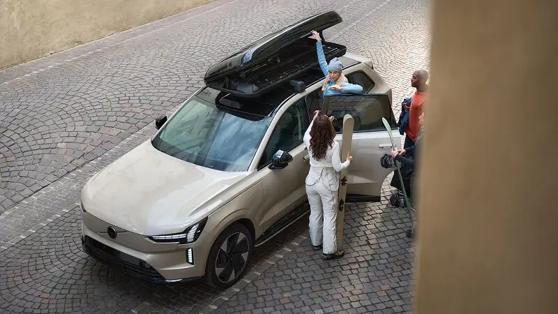 Béžové Volvo EX90 so strešným boxom a lyžiarskou výbavou – priestranné 7-miestne elektrické SUV pre rodiny