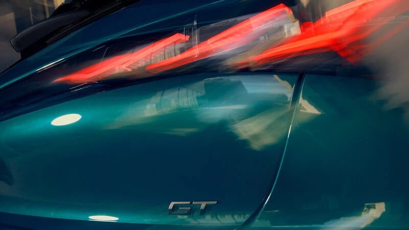 Detail zadného LED svetla a chrómovaného GT loga na Peugeot 308 v smaragdovej farbe